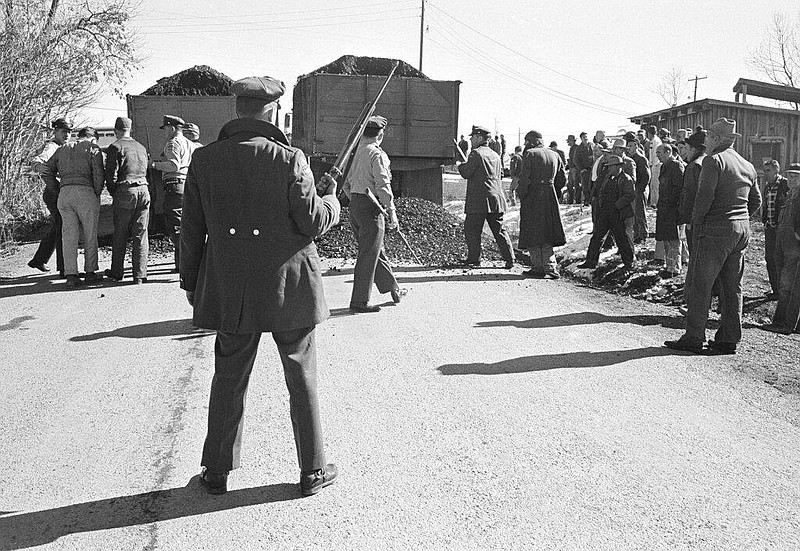 Armed state guards clear the road of union pickets to let trucks loaded with non-union coal pass through at Grays Creek, Whitwell, Tennessee April 1, 1963. (AP Photo)