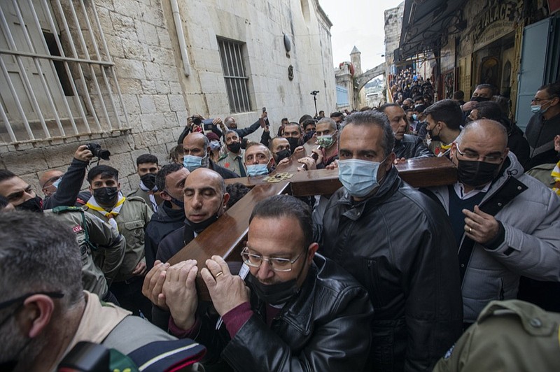 Christians carry a cross along the Via Dolorosa towards the Church of the Holy Sepulchre, believed by many to be the site of the crucifixion of Jesus Christ, during the Good Friday procession in Jerusalem's old city, Friday, April 2, 2021. (AP Photo/Ariel Schalit)


