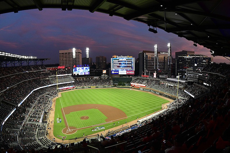 In this Oct. 7, 2018, file photo, ground crews prepare the field at Sun Trust Park, now known as Truist Park, ahead of Game 3 of MLB baseball's National League Division Series between the Atlanta Braves and the Los Angeles Dodgers in Atlanta. Truist Park lost the 2021 All-Star Game on Friday, April 2, 2021, when Major League Baseball decided to move the game elsewhere over the league's objection to Georgia's sweeping new election law that critics say restricts voting rights. (AP Photo/John Amis, File)