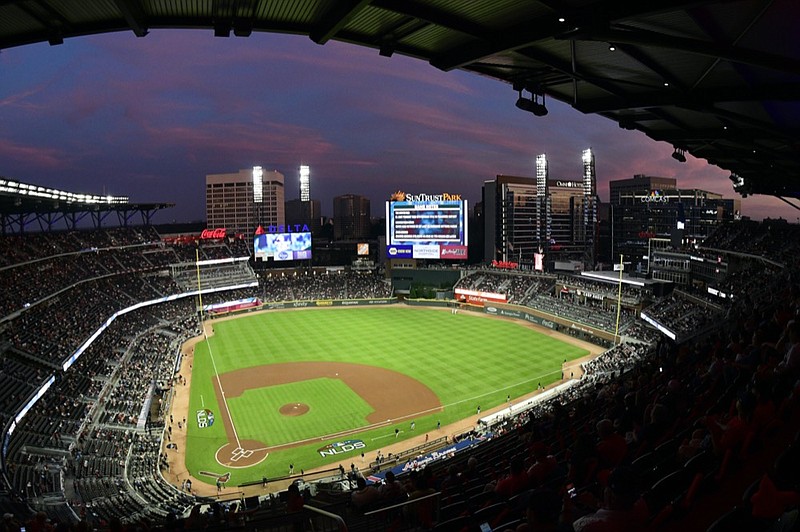 FILE - In this Oct. 7, 2018, file photo, ground crews prepare the field at Sun Trust Park, now known as Truist Park, ahead of Game 3 of MLB baseball's National League Division Series between the Atlanta Braves and the Los Angeles Dodgers in Atlanta. (AP Photo/John Amis, File)


