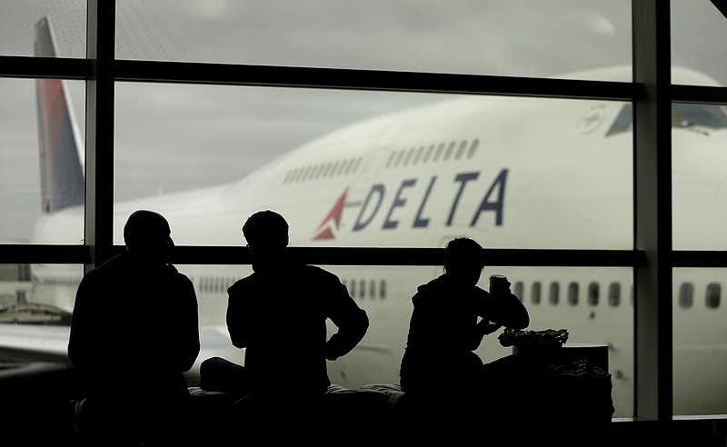 AP Photo/Charlie Riedel /	Travelers on Delta Airlines waits for flights in Detroit. Delta is resuming more flights as the pandemic lessens, but some flights have been scrapped due to staffing shortages.