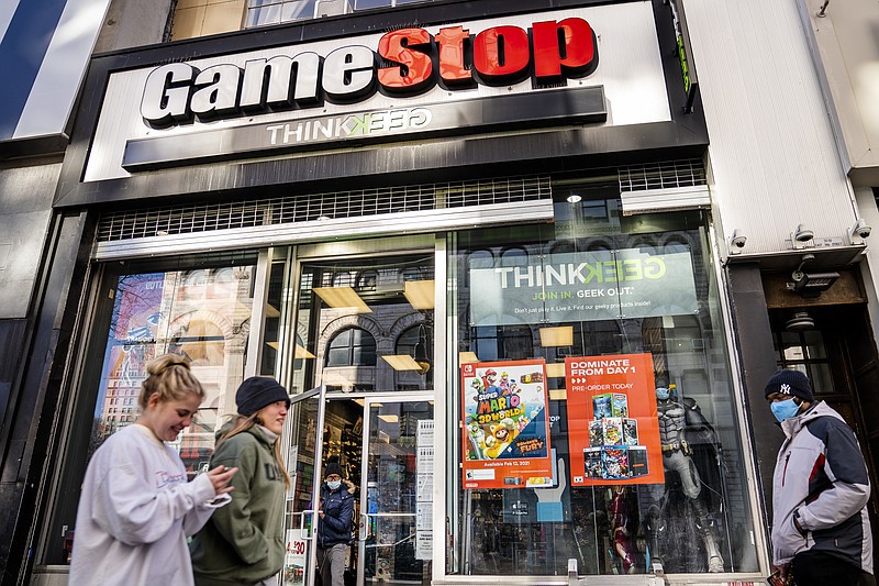 FILE - In this Jan. 28, 2021, file photo, pedestrians pass a GameStop store on 14th Street at Union Square, in the Manhattan borough of New York. GameStop says it's selling up to 3.5 million of its shares, a move that will allow the video-game retailer to take advantage of the big surge in its stock price this year. The company said the shares will be sold through an "at-the-market" offering, which lets a publicly traded company raise capital over time by offering securities into the already existing trading market. (AP Photo/John Minchillo, File)