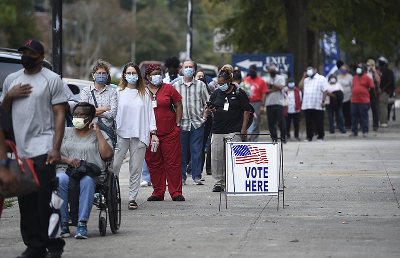 Augusta Chronicle file photo via The Associated Press / In this Oct. 12, 2020, file photo, people wait in line for early voting at the Bell Auditorium in Augusta, Ga. The sweeping rewrite of Georgia's election rules signed into law by Republican Gov. Brian Kemp recently is now receiving corporate backlash. Georgia's new, 98-page law makes numerous changes, including a new photo ID requirement for voting absentee by mail.