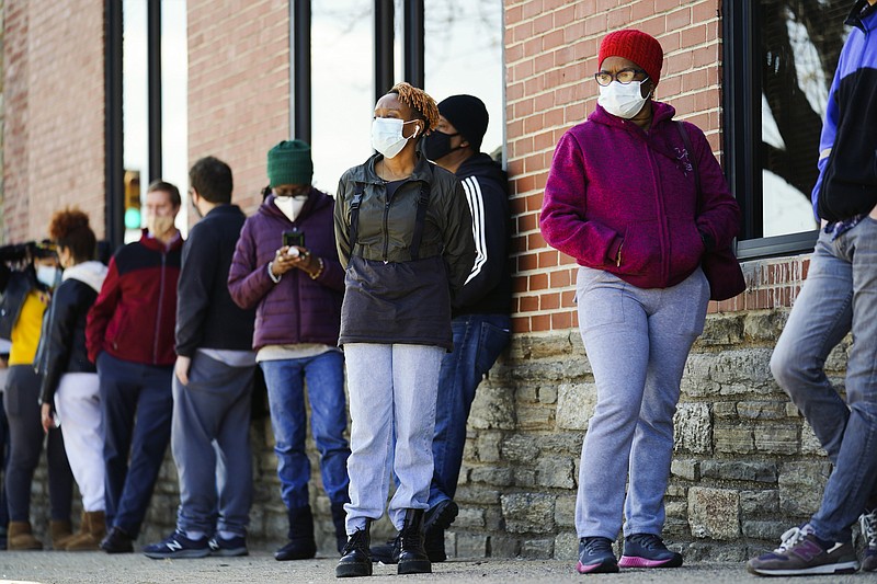 In this March 29, 2021, file photo, people wearing face masks as a precaution against the coronavirus wait in line to receive COVID-19 vaccines at a site in Philadelphia. Nearly half of new coronavirus infections nationwide are in just five states, including Pennsylvania — a situation that puts pressure on the federal government to consider changing how it distributes vaccines by sending more doses to hot spots. (AP Photo/Matt Rourke, File)
