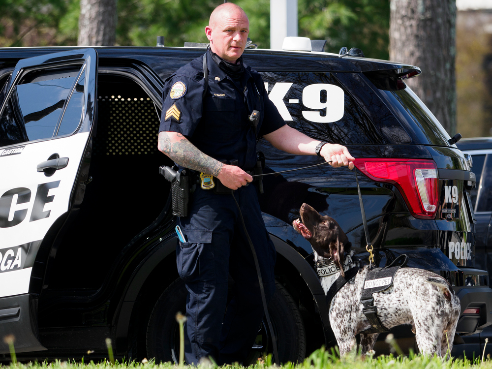 Staff photo by C.B. Schmelter / Chattanooga Police Department Sgt. Sean O'Brien prepares to run a demonstration search for a firearm with K9 Gunther during a press conference at the Tennessee Riverpark on Wednesday, April 7, 2021 in Chattanooga, Tenn.