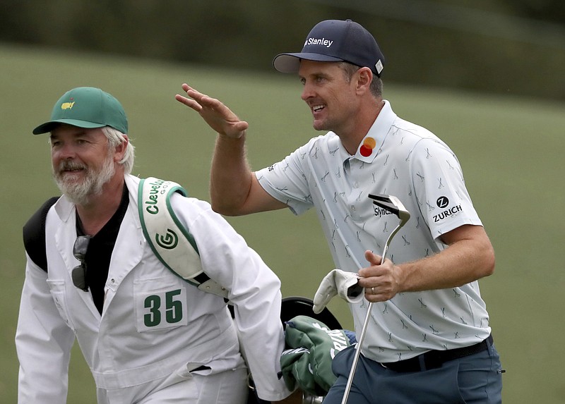 Atlanta Journal-Constitution photo by Curtis Compton via AP / Justin Rose and his caddie, David Clark, react to his second shot on the eighteenth hole during the first round of the Masters on Thursday in Augusta, Ga. Rose shot a 65 and led by four strokes on a day when the average score 74.5.