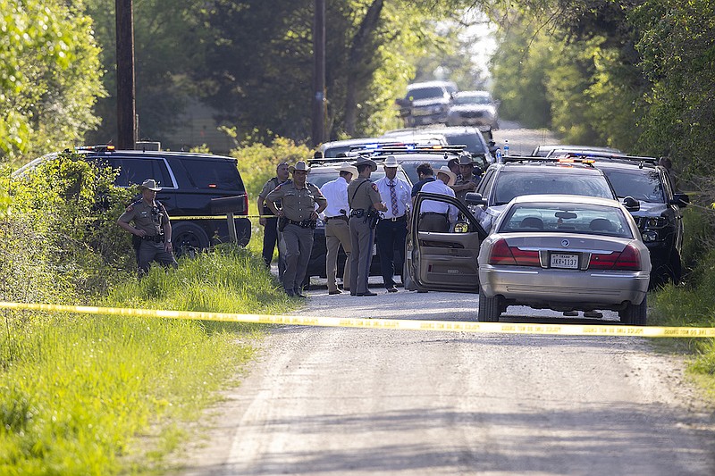 First responders work at the scene of the apprehension of a suspect at a residence in Bedias, Texas, Thursday, April 8, 2021, following a shooting at Kent Moore Cabinets in Bryan, Texas. One person was killed and several people were wounded Thursday in the wake of a shooting at the cabinet-making business in Bryan, authorities said, and a state trooper was later shot during a manhunt that resulted in the suspected shooter being taken into custody. (Michael Miller/College Station Eagle via AP)