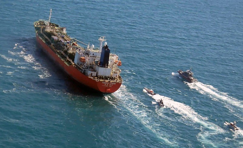 In this Jan. 4, 2021, file photo released by Tasnim News Agency, a seized South Korean-flagged tanker is escorted by Iranian Revolutionary Guard boats on the Persian Gulf. The South Korean oil tanker held for months by Iran amid a dispute over billions of dollars held in Seoul was leaving Iran early Friday, April 9, 2021. (Tasnim News Agency via AP, File)