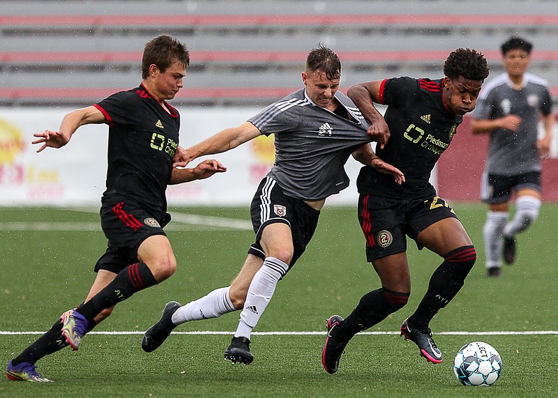 Staff photo by Troy Stolt / Chattanooga Red Wolves forward Jackson Dietrich, center, fights for possession during a preseason match against Atlanta United 2 on Saturday at CHI Memorial Stadium in East Ridge.