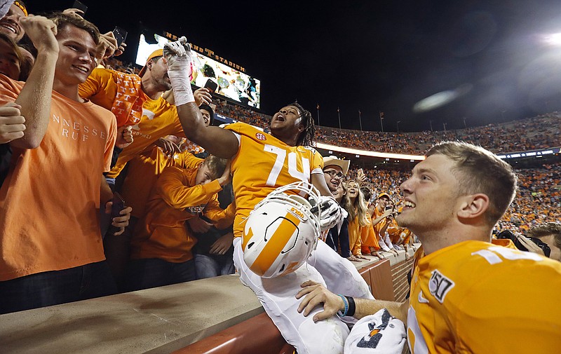 AP photo by Wade Payne / Tennessee offensive lineman K'Rojhn Calbert (74) and quarterback Brian Maurer celebrate with fans after the Vols' 41-21 win over South Carolina on Oct. 26, 2019, in Knoxville.