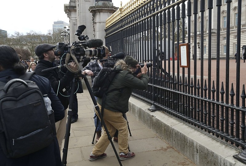 FILE - In this Friday, April 9, 2021 file photo, members of the media take images of an announcement, regarding the death of Britain's Prince Philip, displayed on the fence of Buckingham Palace in London. (AP Photo/Matt Dunham, File)


