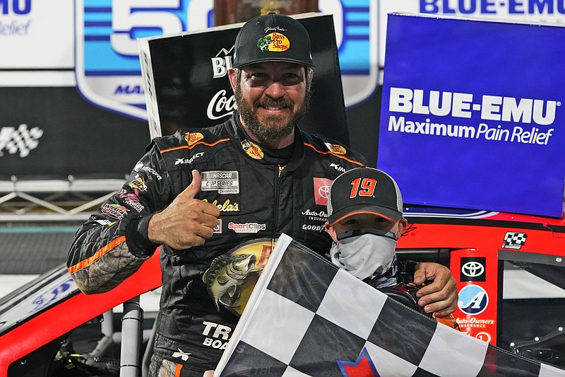 AP photo by Steve Helber / Martin Truex Jr. celebrates with a fan after winning a NASCAR Cup Series race Sunday at Martinsville Speedway in Martinsville, Va.