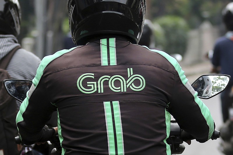 FILE - In this July 24, 2017, file photo, a GrabBike driver rides on his motorbike in Jakarta, Indonesia. Southeast Asia's largest ride-hailing company, Grab Holdings, said Tuesday, April 13, 2021 that it plans to merge with U.S.-based Altimeter Growth Capital in a deal that would value it at nearly $40 billion in preparation for an initial public offering in the U.S. (AP Photo/Tatan Syuflana, File)