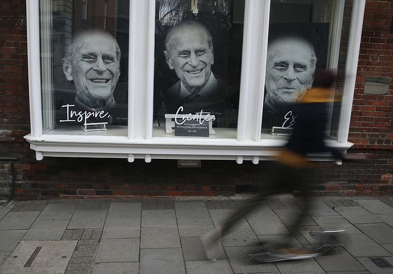 Portraits of the Prince Philip Duke of Edinburgh are displayed in the window of an art gallery following the death of the Duke of Edinburgh at the age of 99, in Windsor, England, Tuesday April 13, 2021. The funeral for Prince Philip is scheduled for upcoming Saturday. (Steve Parsons/PA via AP)