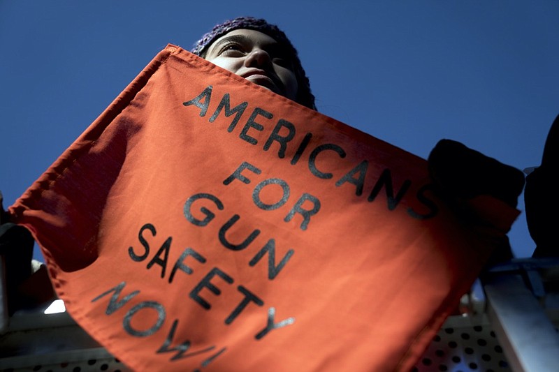 FILE - In this March 24, 2018, file photo, Isabel White of Parkland, Fla., holds a sign that reads "Americans for Gun Safety Now!" during the "March for Our Lives" rally in support of gun control in Washington, that was spearheaded by teens from Marjory Stoneman Douglas High School after the 2018 mass shooting in Parkland, Fla. President Biden faces an uphill battle as he tries to push for more state laws that would allow authorities to temporarily disarm people who are considered a danger to themselves or others. State lawmakers, governors of both parties and former President Donald Trump embraced the so-called red flag laws after the 2018 mass shooting in Florida. (AP Photo/Andrew Harnik, File)