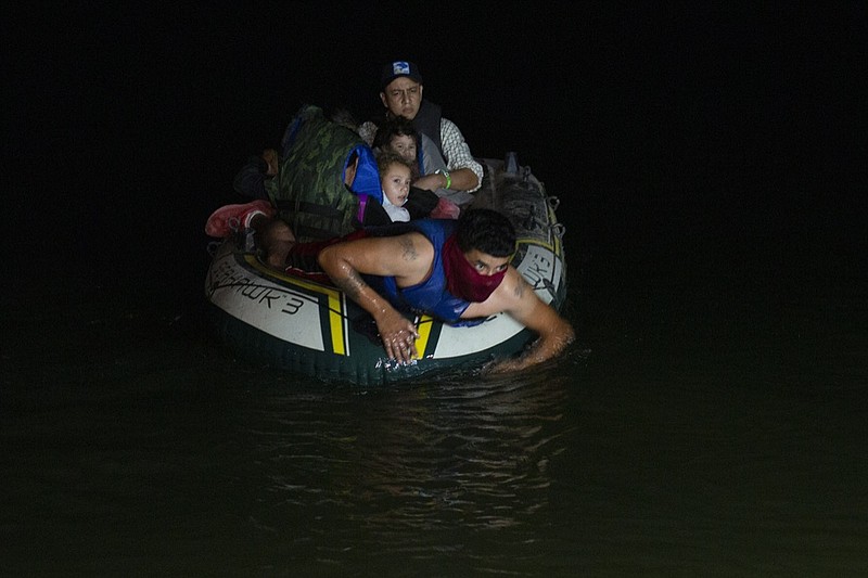 FILE - In this March 30, 2021 file photo, a smuggler takes migrants, mostly from Central American countries, on a small inflatable raft towards U.S. soil, in Roma, Texas. Mexico President Andres Manuel Lopez Obrador said Wednesday, April 14, 2021, it was protecting human rights that was motivating Mexico's efforts to stop child migrants en route to the U.S. from being smuggled into the country. (AP Photo/Dario Lopez-Mills, File)