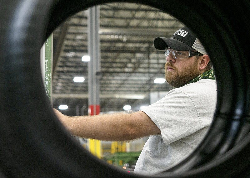 Staff photo by C.B. Schmelter / Michael Leonard is framed by a "green tire" at Nokian Tyres on Thursday, April 8, 2021 in Dayton, Tenn.