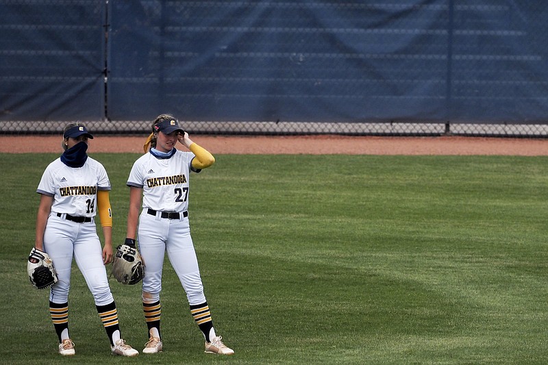 Staff photo by C.B. Schmelter / UTC center fielder Gracey Kruse (27) and left fielder Addy Keylon talk in between innings during the first game of a doubleheader against UNC Greensboro on Saturday at Frost Stadium.