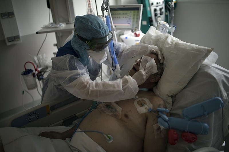 FILE - In this Feb. 2, 2021, file photo, a nurse cleans a patient suffering from COVID-19 in the ICU at the La Timone hospital in Marseille, southern France. (AP Photo/Daniel Cole, File)


