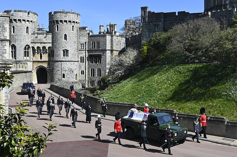 Britain's Prince Charles, from front left, Princess Anne, Prince Andrew. Prince Edward, Prince William, Peter Phillips, Prince Harry, Earl of Snowdon, Tim Laurence and Queen Elizabeth II, in car at rear, follow the coffin as it makes it's way past the Round Tower during the funeral of Britain's Prince Philip inside Windsor Castle in Windsor, England Saturday April 17, 2021. (Leon Neal/Pool via AP)

