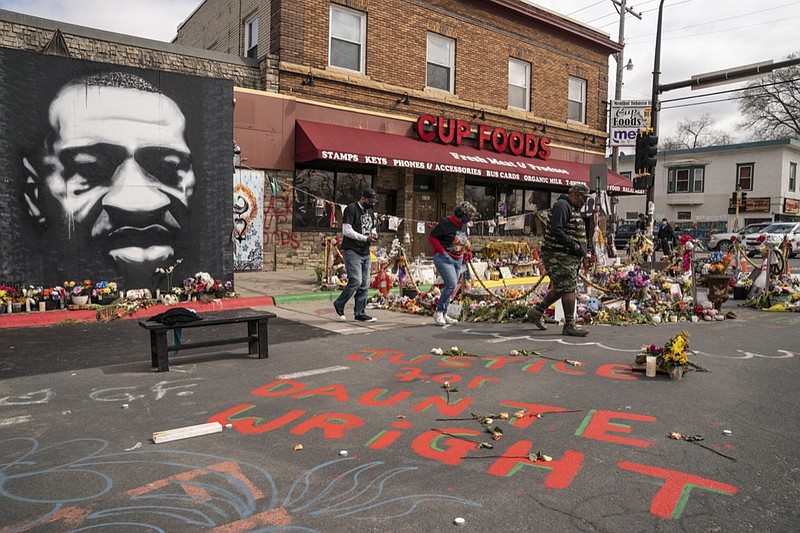 Visitors browse a memorial to George Floyd as a new addition commemorating Daunte Wright is displayed outside Cup Foods, Wednesday, April 14, 2021, in Minneapolis, Minn. (AP Photo/John Minchillo)

