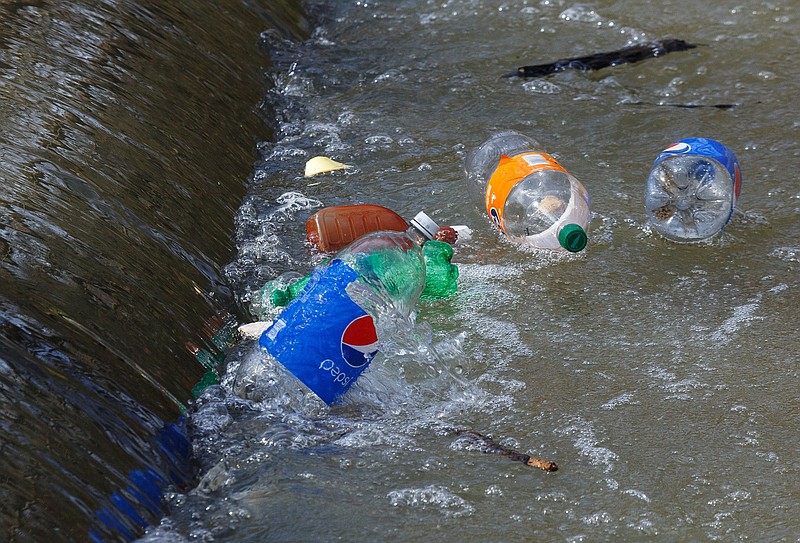 Staff File Photo / Trash, despite cleanup efforts over the years by volunteers, floats in Chattanooga Creek in this 2019 photograph.