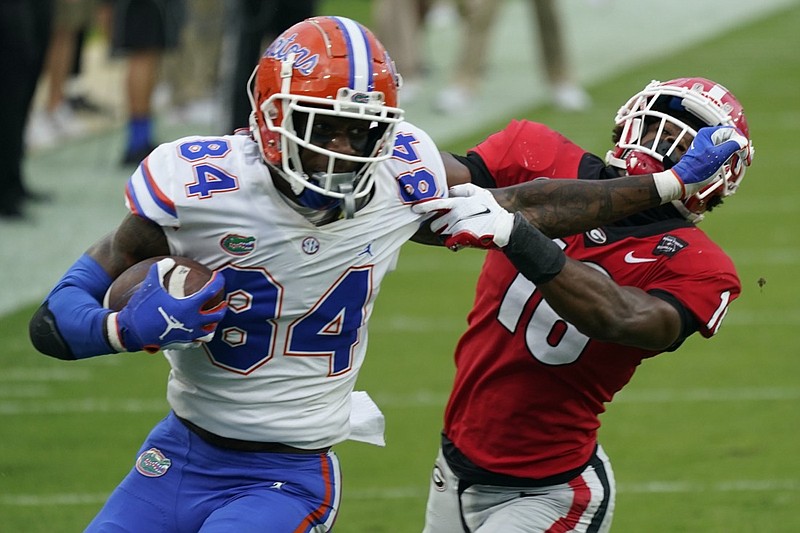 FILE - Florida tight end Kyle Pitts (84) tires to get past Georgia defensive back Lewis Cine (16) after a reception during the first half of an NCAA college football game in Jacksonville, Fla., in this Saturday, Nov. 7, 2020, file photo. Kyle Pitts is arguably one of the most dynamic playmakers in the NFL draft. (AP Photo/John Raoux, File)