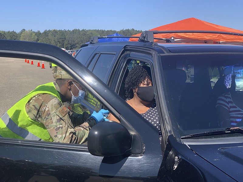 Alabama National Guard Sgt. Antwan Marshall gives a COVID-19 vaccination to Shirley Thompson on Friday, April 2, 2021 during a clinic at Wilcox High School in Camden, Ala. (AP Photo/Kim Chandler)