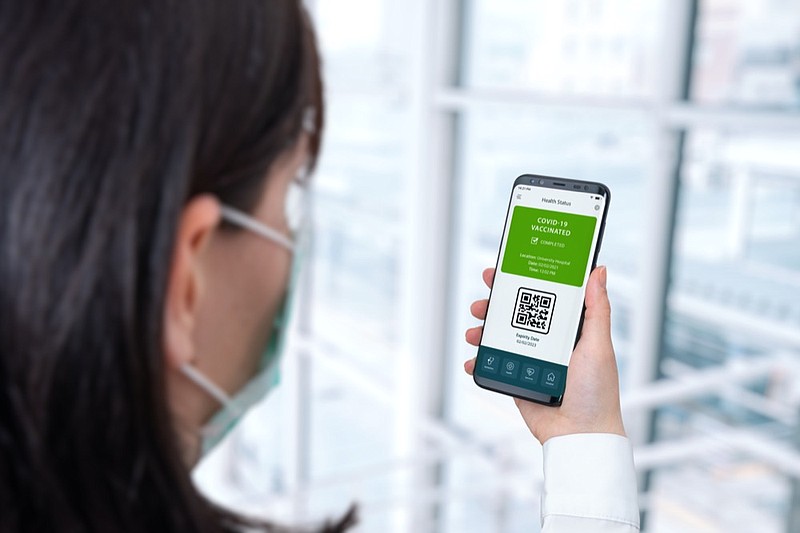 Covid vaccination authentication with app on smart phone concept. Woman holding smart phone on airport. Travel vaccine passport concept - stock photo / Getty Images
