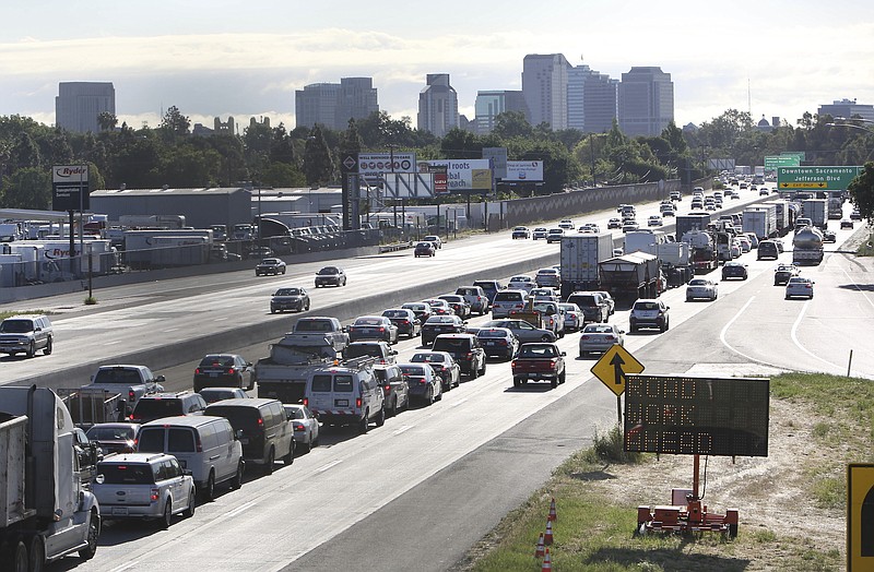FILE - In this April 22, 2014 file photo, drivers enter Sacramento on Highway 50 to come to a near stand still as traffic backs up in West Sacramento, Calif. The U.S. Transportation Department is moving to reverse former President Donald Trump's bid to end California's ability to set its own automobile tailpipe pollution standards. The National Highway Traffic Safety Administration, which is part of the DOT, said Thursday, April 22, 2021 it is proposing to withdraw a rule rule meant to stop states from setting their own requirements for greenhouse gases, zero emissions vehicles and fuel economy. .(AP Photo/Rich Pedroncelli, File)