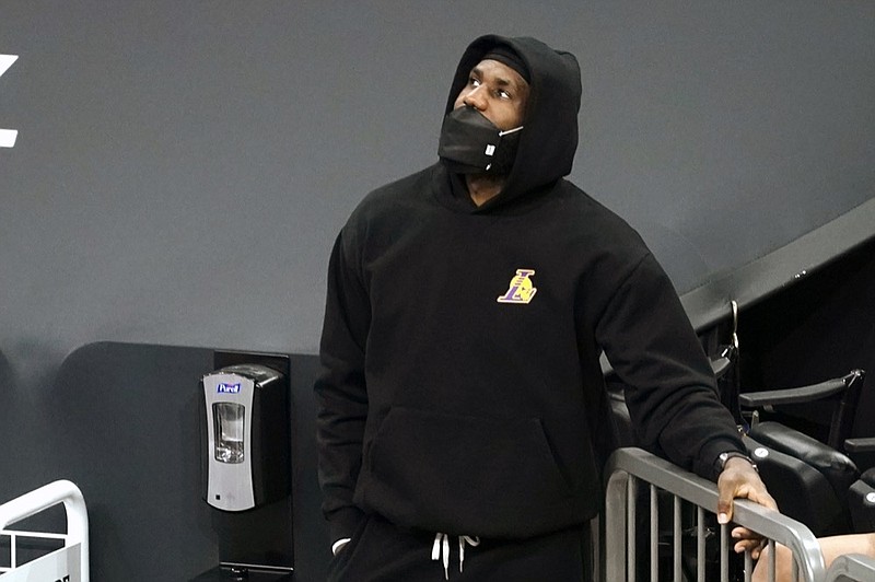 Los Angeles Lakers forward LeBron James (23) watches from the sideline during the first half of an NBA basketball game against the Phoenix Suns, Sunday, March 21, 2021, in Phoenix. (AP Photo/Rick Scuteri)


