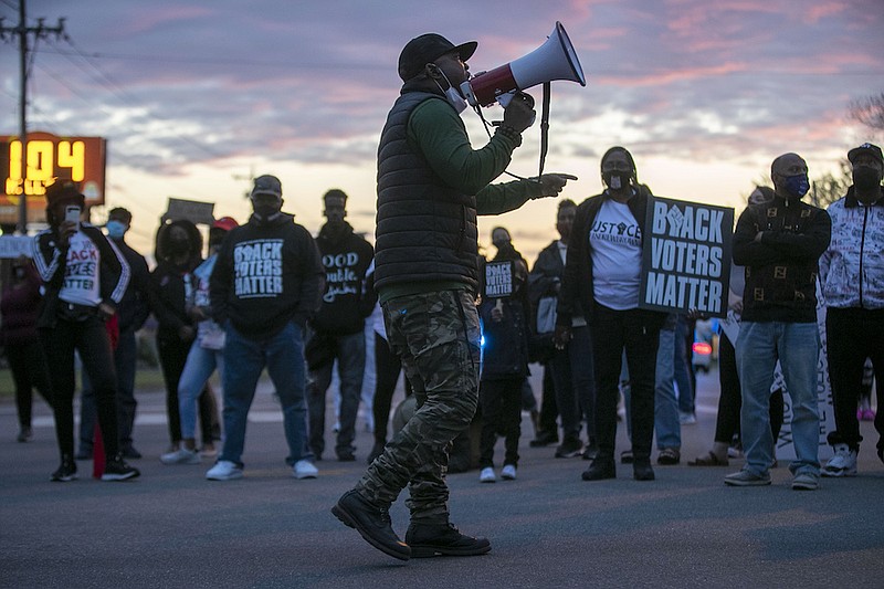 Tony Riddick addresses demonstrators at the intersection of Ehringhaus Street and Road Street during a march on Friday, April 23, 2021, in Elizabeth City, N.C. Authorities say seven North Carolina deputies have been placed on leave in the aftermath of a Black man being shot and killed by members of their department serving drug-related search and arrest warrants. The disclosure comes as calls increase for the release of deputy body camera footage amid signs that Andrew Brown Jr. was shot in the back and killed as he was trying to drive away. (Robert Willett/The News & Observer via AP)