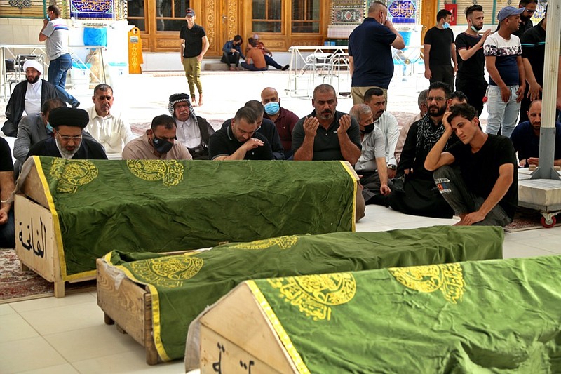 Mourners pray near the coffins of coronavirus patients who were killed in a hospital fire, during their funeral at the Imam Ali shrine in Najaf, Iraq, Sunday, April 25, 2021. Iraq's Interior Ministry said Sunday that over 80 people died and over 100 were injured in a catastrophic fire that broke out in the intensive care unit of a Baghdad hospital tending to severe coronavirus patients in the early morning Sunday. (AP Photo/Anmar Khalil)