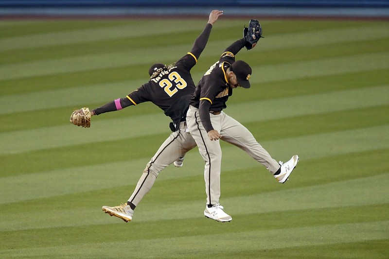 San Diego Padres shortstop Fernando Tatis Jr., left, celebrates by leaping with center fielder Trent Grisham after the Padres defeat the Los Angeles Dodgers 8-7 in 11 innings of a baseball game in Los Angeles, Sunday, April 25, 2021. (AP Photo/Alex Gallardo)