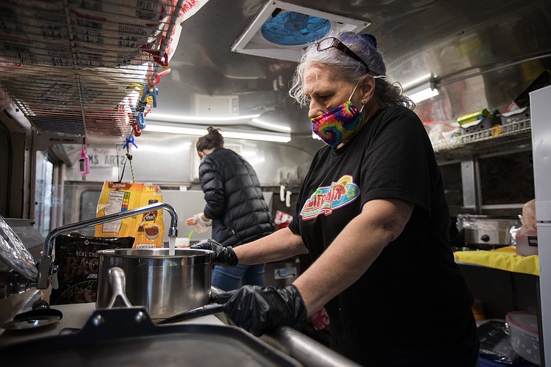 Staff photo by Troy Stolt / Jenny Cowart and Dene Shull work to clean up the California Smothered Burrito food truck following its visit to St. Jude Elementary School.
