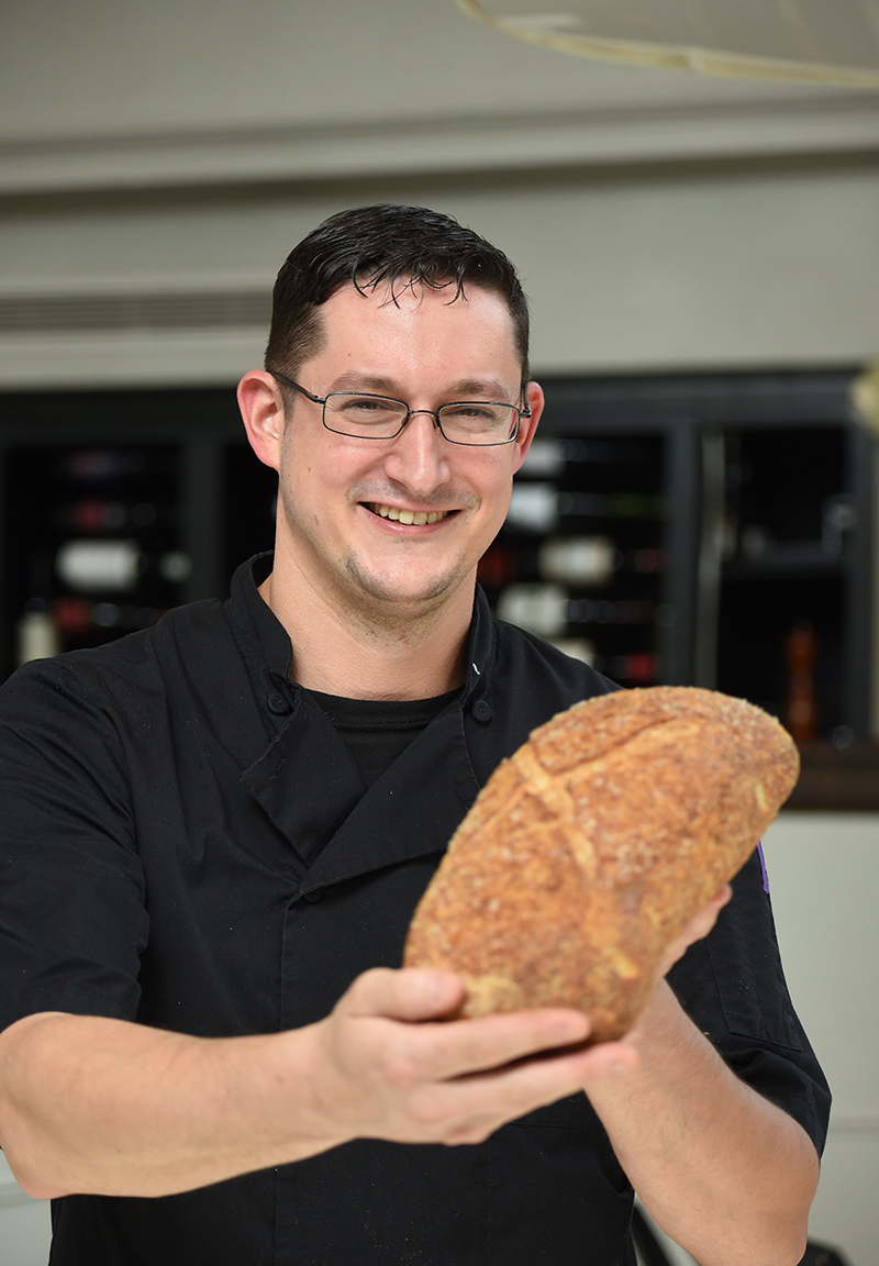 Staff photo by Matt Hamilton / Chef Dane Frazier shows off a loaf of his rosemary sourdough.