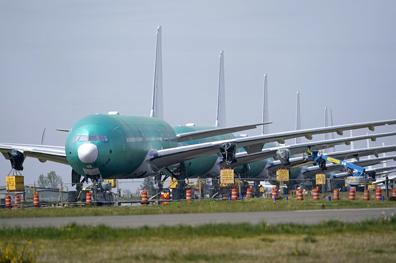 A line of Boeing 777X jets are parked nose to tail on an unused runway at Paine Field, near Boeing's massive production facility, Friday, April 23, 2021, in Everett, Wash. Boeing Co. on Wednesday, April 28, reported a loss of $537 million in its first quarter. The Chicago-based company said it had a loss of 92 cents per share. Losses, adjusted for non-recurring gains, were $1.53 per share. (AP Photo/Elaine Thompson)