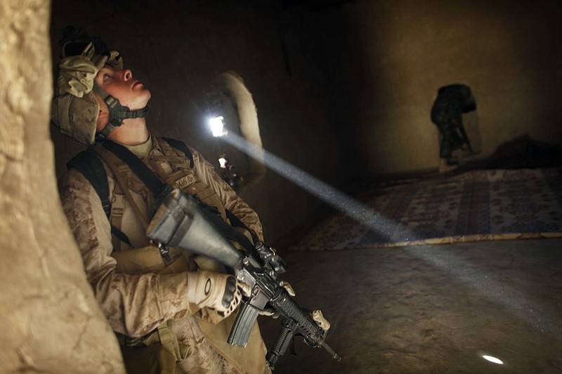 FILE - In this Dec. 23, 2009 file photo, United States Marine LCpl. Franklin Romans of Michigan, from the 2nd Battalion 2nd Marines "Warlords" searches a house during an operation in the Garmsir district of the volatile Helmand province, southern Afghanistan. (AP Photo/Kevin Frayer, File)


