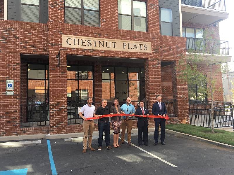 Photo by Dave Flessner / Then-Mayor Andy Berke, U.S. Rep. Chuck Fleischmann and Hunter Nelson, from right, join other lending and development leaders to cut the ribbon for the Chestnut Flats apartments on the Southside in 2019.