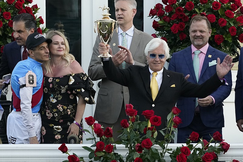 AP photo by Jeff Roberson / Jockey John Velazquez, left, watches as trainer Bob Baffert holds up the winner's trophy after their victory with Medina Spirit in the 147th running of the Kentucky Derby at Churchill Downs on Saturday in Louisville.