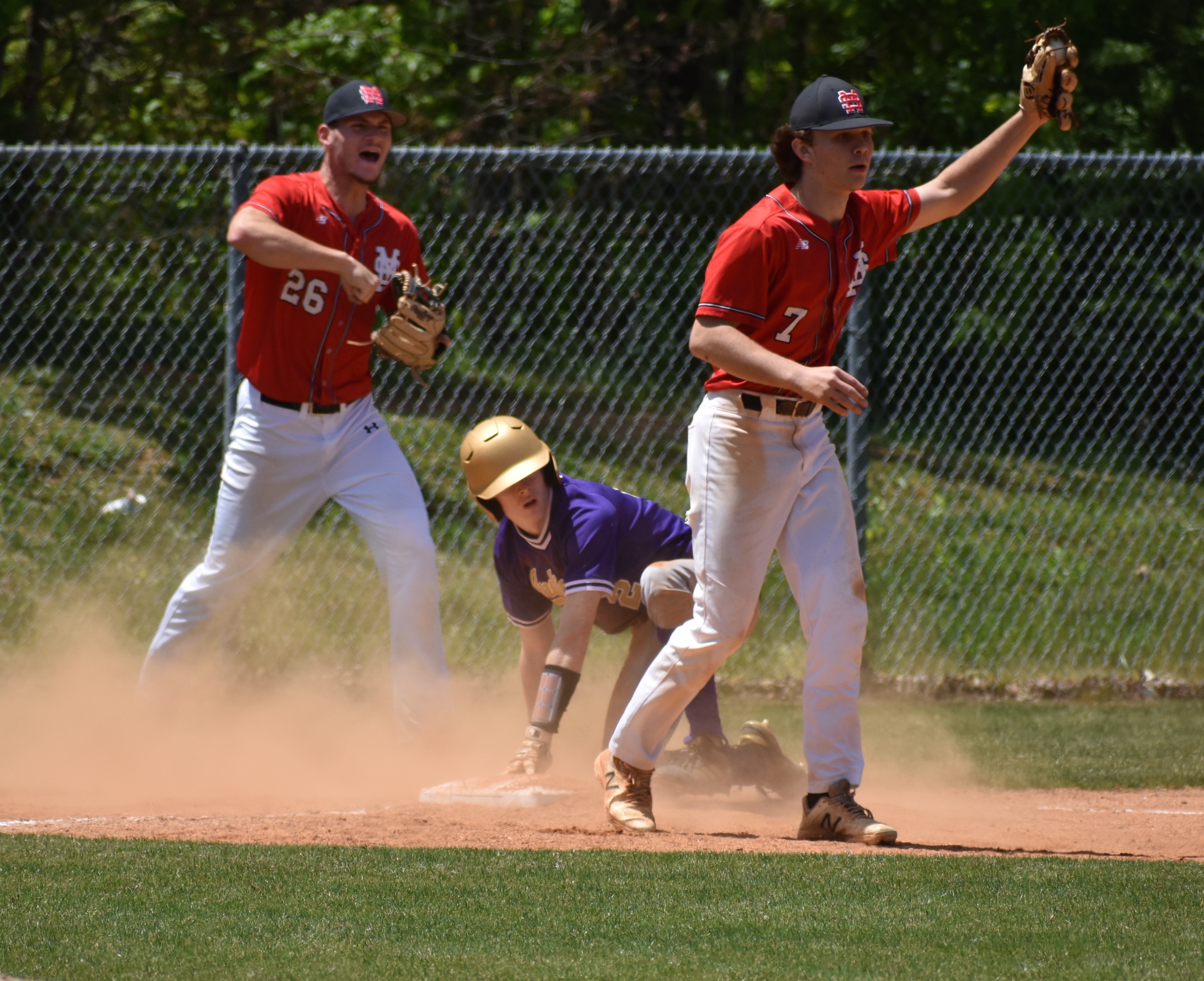 Signal Mountain senior Preston Worley raises his glove with the ball in it after tagging out Sequatchie County's Ethan Seals during Saturday's game at Signal Mountain. Eagles pitcher Braeden Wolfard celebrates in the background.
