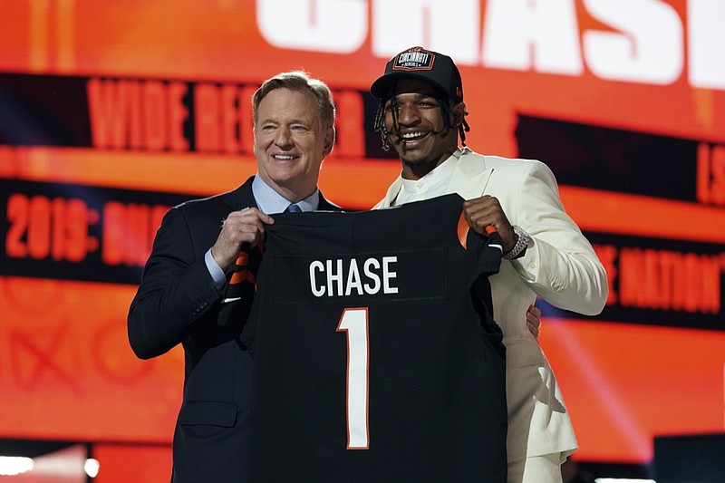 LSU wide receiver Ja'Marr Chase, right, holds a team jersey with NFL Commissioner Roger Goodell after the Cincinnati Bengals selected Pitts with the fourth pick in the first round of the NFL football draft, Thursday, April 29, 2021, in Cleveland. (AP Photo/Steve Luciano)