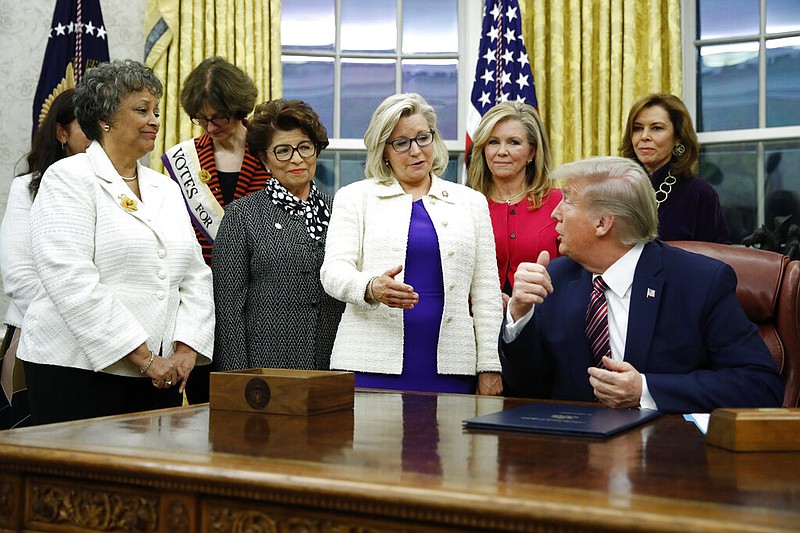In this Nov. 25, 2019, file photo, Rep. Liz Cheney, R-Wyo., center, speaks with President Donald Trump during a bill signing ceremony for the Women's Suffrage Centennial Commemorative Coin Act in the Oval Office of the White House in Washington. Trump and his supporters are intensifying efforts to shame members of the party who are seen as disloyal to the former president and his false claims that last year's election was stolen from him.(AP Photo/Patrick Semansky, File)