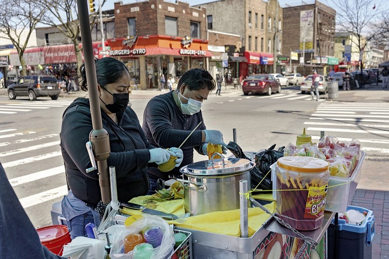 Ruth Palacios and Arturo Xelo, a married couple from Mexico, work at their fruit stand in the Corona neighborhood of the Queens borough of New York on Tuesday, April 13, 2021. They worked seven days a week for months disinfecting COVID-19 patient rooms at the Memorial Sloan Kettering Cancer Center in New York City, but weren't paid overtime Palacios says. The couple filed a federal lawsuit against the contractor that hired them, alleging their pay was cut without their knowledge from $15 an hour to $12.25. (AP Photo/Marshall Ritzel)


