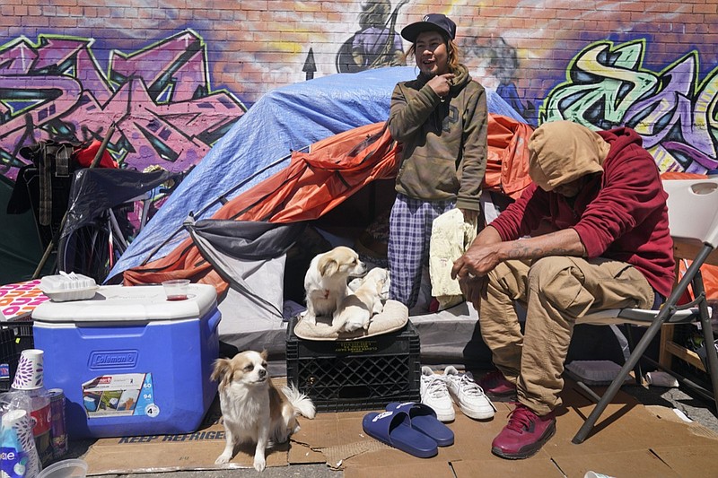 Lucio Lopez, left, talks with friends as he stands in a tent that is part of a homeless encampment in the Queens borough of New York, Tuesday, April 13, 2021. Unemployment among Hispanic immigrants has doubled in the U.S., going from 4.8% in January 2020 to 8.8% in February 2021, according to the Migration Policy Institute. These numbers don't take into consideration immigration status but activists and social workers in states like New York or California say more vulnerable immigrants, whom often don't qualify for aid, are finding themselves without a home. (AP Photo/Seth Wenig)