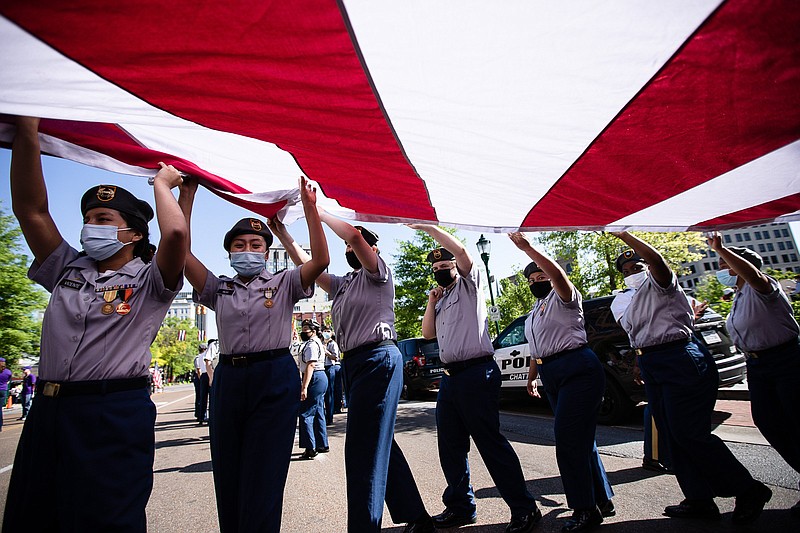 Staff photo by Troy Stolt / East Ridge high school JROTC members work to flip the orientation of a giant American Flag so that it will be seen properly before the 72nd annual Armed Forces Day parade in downtown  Chattanooga, Tenn on Friday, May 7, 2021.