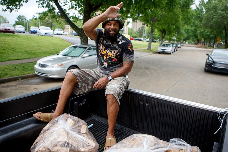 Staff photo by C.B. Schmelter / Tony Oliver waves as he helps deliver lunches to the residents of the towers on the Westside on Tuesday, May 5, 2020 in Chattanooga, Tenn.