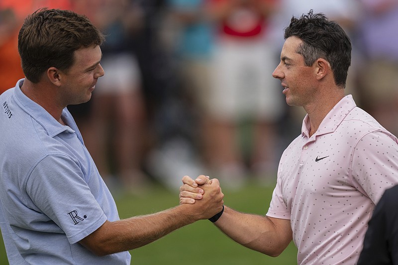 AP photo by Jacob Kupferman / Chattanooga native Keith Mitchell, left, congratulates Rory McIlroy on his win in the PGA Tour's Wells Fargo Championship on Sunday at Quail Hollow Club in Charlotte, N.C. Mitchell, who led by two strokes after three rounds, tied for third.