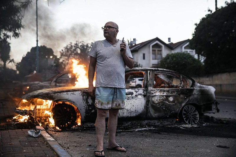 Jacob Simona stands by his burning car during clashes with Israeli Arabs and police in the Israeli mixed city of Lod, Israel Tuesday, May 11,2021. (AP Photo/Heidi Levine)

