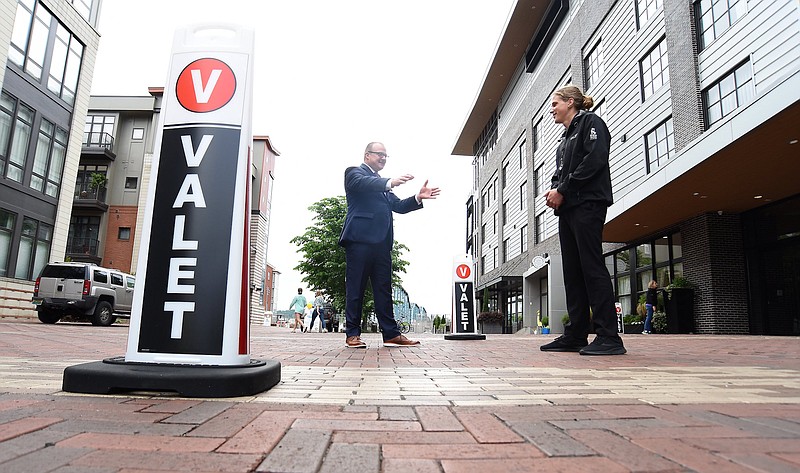 Staff Photo by Matt Hamilton / Brook Weresuk, left, a co-owner and the managing director of Bird Dog Parking, talks with valet Calvin White outside the Edwin Hotel in Chattanooga.